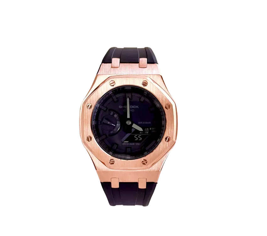 Montre Casio G-Shock avec cadran noir, lunette en or rose et bracelet noir.