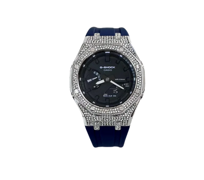 Montre Casio G-Shock élégante avec boîtier serti de cristaux scintillants, cadran noir fonctionnel et bracelet en silicone bleu foncé pour une allure moderne et robuste.