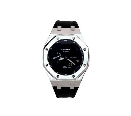 Montre Casio G-Shock avec un cadran noir brillant, boîtier en métal argenté robuste et bracelet en silicone noir, combinant élégance et durabilité pour un style polyvalent.