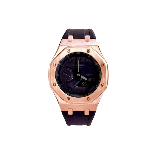 Montre Casio G-Shock avec cadran noir, lunette en or rose et bracelet noir.