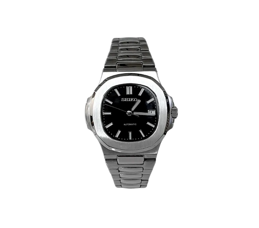 Montre automatique Seiko avec cadran noir, index et aiguilles argentés, boîtier en acier inoxydable brossé, bracelet en métal assorti et affichage de la date à 3 heures.